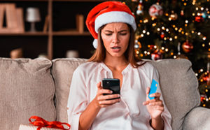 Lady looking at phone and holding credit card
