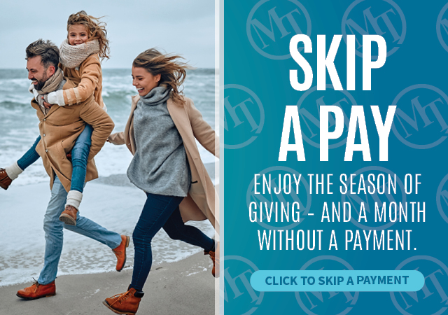 Family running on the beach in winter clothing next to text promoting a Skip-A-Pay holiday offer.